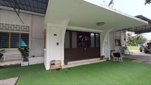 a front porch of a house with green grass at Homestay Laman Dahlia in Kuala Kangsar