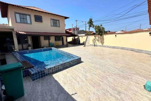 ein Pool vor einem Haus in der Unterkunft Casa 3 quartos com piscina e churrasqueira in Cabo Frio