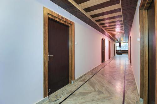 un corridoio con porta nera e soffitti in legno di Hotel Mehraz Residency a Haldwāni