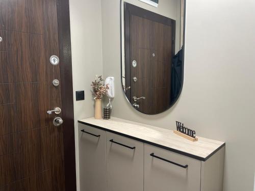a bathroom with a sink with a mirror and a door at Kristin`s Home in Burgas