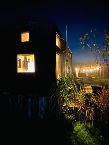 a building with a window in the dark at Heaven Reset Spa Luksusowy Glamping Jacuzzi w Naturze Blisko Warszawy in Korczew