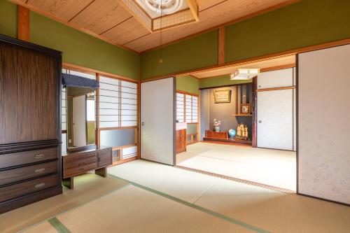 Cette chambre est dotée de murs verts et de plafonds en bois. dans l'établissement アルマス伊王島, à Nagasaki