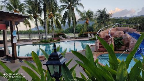 a pool at a resort with a rock slide at Villa Dalam Laut 538 in Pantai Cenang