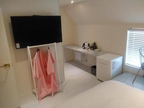 a small kitchen with a tv in a room at 해운대 모모쥬스호텔 부산 MoMo Juice Busan Haeundae in Busan