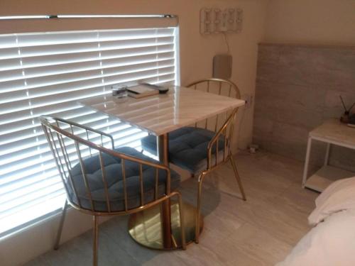 a table and chairs in a room with a window at 해운대 모모쥬스호텔 부산 MoMo Juice Busan Haeundae in Busan
