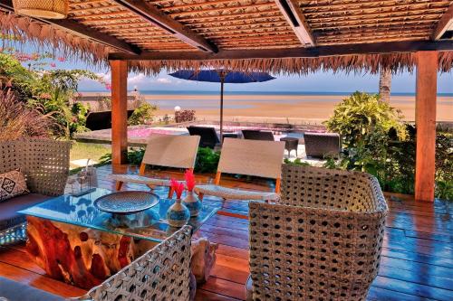 a patio with a table and chairs and the beach at Luxury Sakina Villa - Beachfront in Dzamandzar