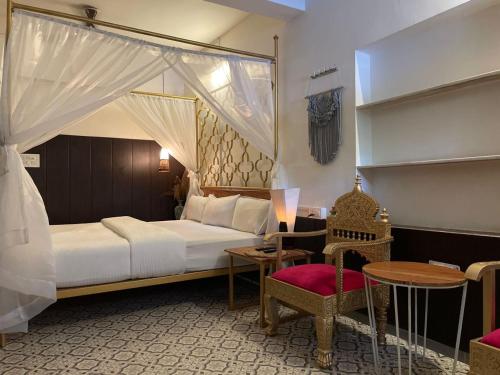 um quarto com uma cama, uma mesa e uma cadeira em Auspicious villa em Udaipur
