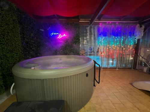 - un bain à remous dans une pièce avec un panneau de néon dans l'établissement Kings Villa near Disneyland reserved only for family with kids, à Saint-Germain-sur-Morin