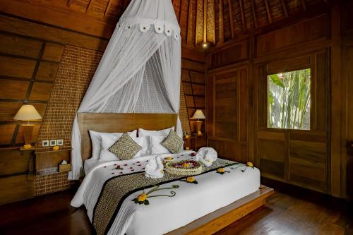 a bedroom with a bed with a canopy at Anandari Ubud Villa in Ubud