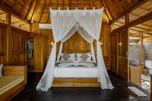 a bedroom with a bed with a canopy at Anandari Ubud Villa in Ubud