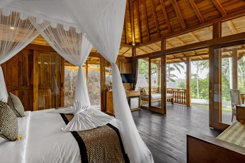 a bedroom with a bed with mosquito nets at Anandari Ubud Villa in Ubud