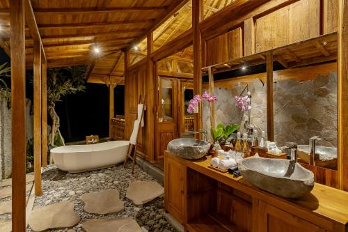 a bathroom with two sinks and a bath tub at Anandari Ubud Villa in Ubud