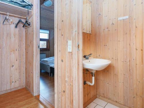 a bathroom with a sink in a wooden wall at Secluded Retreat with Sauna - By Traum Ferienwohnungen in Sønderby