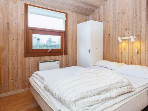 a bedroom with a large bed in a wooden wall at Three-Bedroom Holiday home in Juelsminde 17 in Sønderby