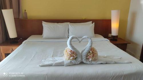 two towelsrendered to look like swans sitting on a bed at Villa Dalam Laut 538 in Pantai Cenang