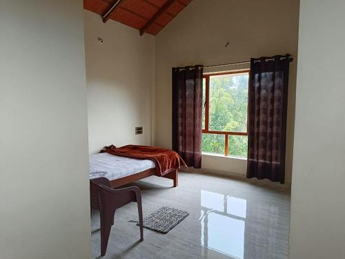 a bedroom with a bed and a large window at Thotadagadde Home stay in Mudigere