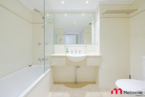 a white bathroom with a sink and a shower at MetaWise Chatswood 1Bed next to station in Sydney