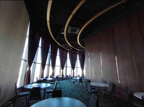 a dining room with tables and chairs in a building at 3 Room/3 Queen Bed, Urban Suite Arcade Room #2carpark in Jelutong