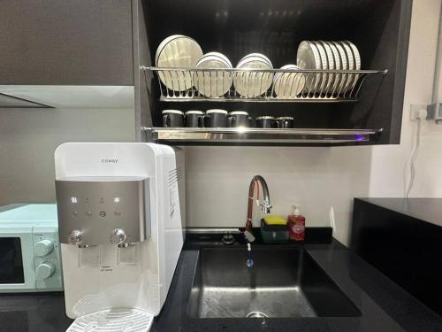 a kitchen counter with a sink and a microwave at 3 Room/3 Queen Bed, Urban Suite Arcade Room #2carpark in Jelutong