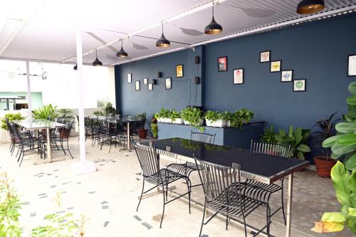 a dining room with tables and chairs and plants at Hotel Pulse Inn- Near Jaipur Railway Station in Jaipur