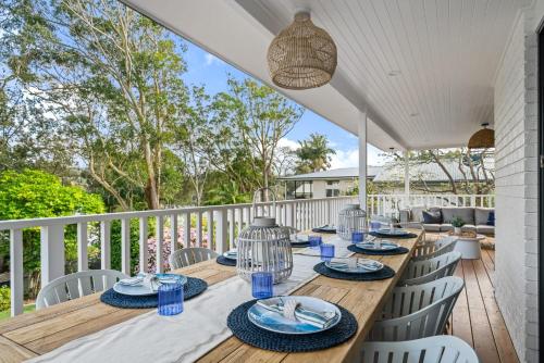 a wooden table with blue dishes on it on a deck at Surf Lodge Avoca Beach Waterfront to Avoca Lake in Avoca Beach
