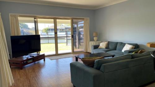 邦加里Ground floor, family unit on the canal with free WIFI!的配有两张沙发和一台平板电视的客厅