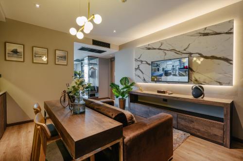 una sala de estar con un sofá y una mesa en Rak Elegant Hotel Patong, en Patong Beach