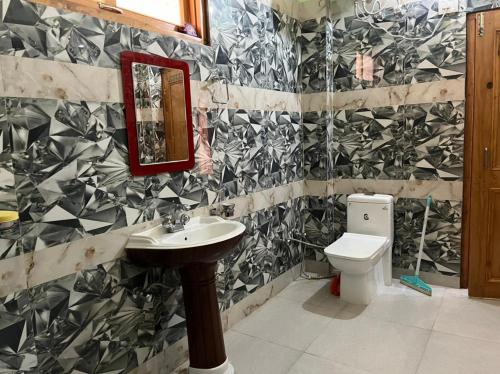 a bathroom with a sink and a toilet at Hotel Anupam in Kasol