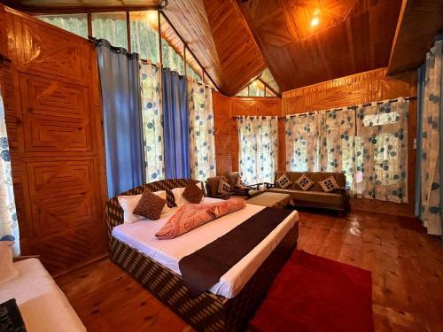 a bedroom with a bed and a couch in a room at Hotel Anupam in Kasol