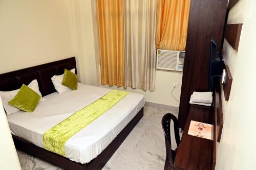a bedroom with a bed with green pillows and a window at Hotel Pulse Inn- Near Jaipur Railway Station in Jaipur