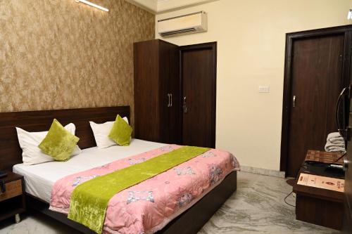 a bedroom with a bed with green and pink sheets at Hotel Pulse Inn- Near Jaipur Railway Station in Jaipur
