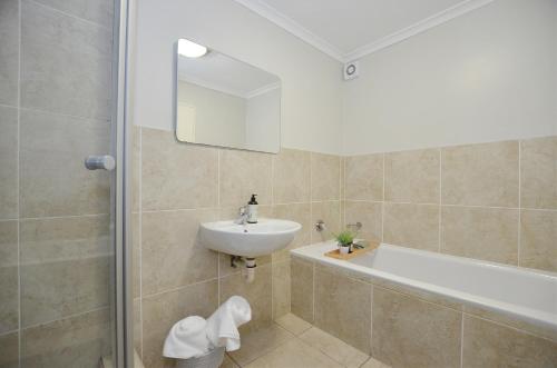 a bathroom with a sink and a bath tub at Apartment in Century City in Cape Town