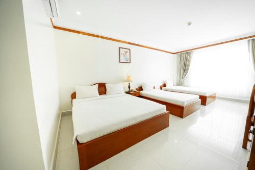 a hotel room with two beds and a window at Pursat Riverside Hotel & Spa in Pursat