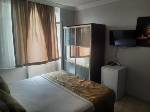 a small bedroom with a bed and a television at Deniz Hotel in Büyükçekmece