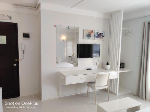 a white room with a desk and a mirror at Mecasa Hotel in Boracay