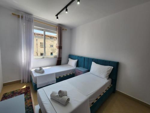 a small room with two beds and a window at Tirana Square Hotel in Tirana