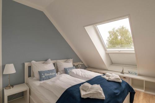a attic bedroom with a bed and a window at Ferienwohnung Heimathafen in Strande