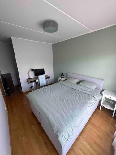 Schlafzimmer mit einem großen weißen Bett und einem Schreibtisch in der Unterkunft 1-bedroom apartment near airport in Petrikyula