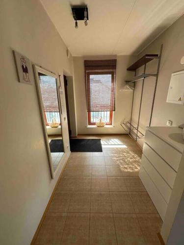 eine Küche mit einem Flur mit einem Waschbecken und einem Fenster in der Unterkunft 1-bedroom apartment near airport in Petrikyula