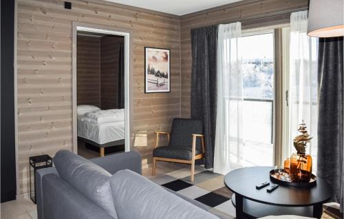 uma sala de estar com um sofá, uma mesa e uma cama em Amazing Apartment In Geilo With House A Mountain View em Geilo