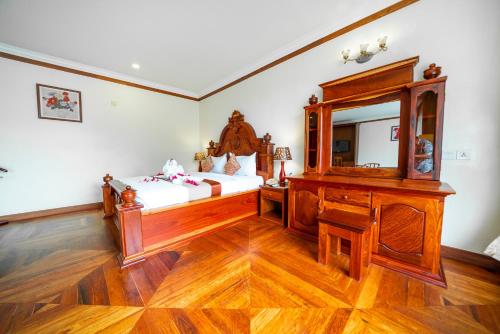 a bedroom with a bed and a mirror at Pursat Riverside Hotel & Spa in Pursat