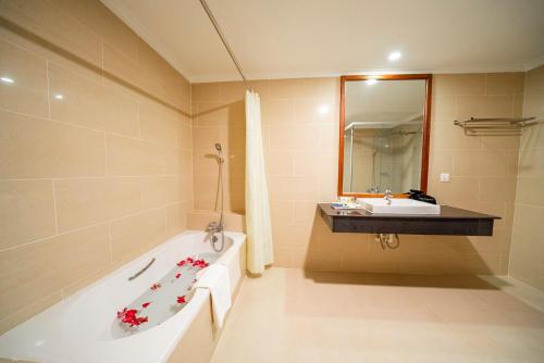 a bathroom with a bath tub and a sink at Pursat Riverside Hotel & Spa in Pursat