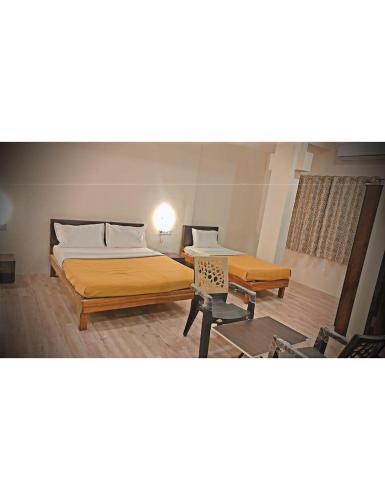 1 dormitorio con 2 camas y mesa en Shangrila's Hotel Sai Chandra, en Shirdi