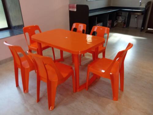 a orange table and chairs in a room at Asmi Palace, Bhaimala, Alibag in Vāgholi