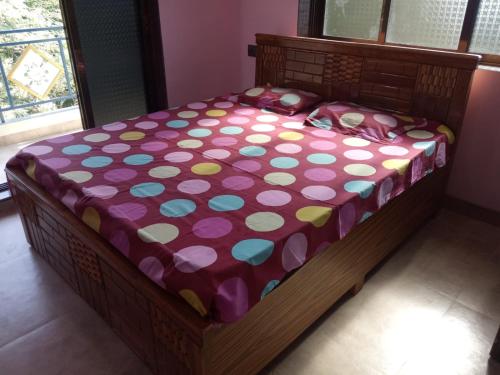 a bed with a polka dot blanket on it at Asmi Palace, Bhaimala, Alibag in Vāgholi