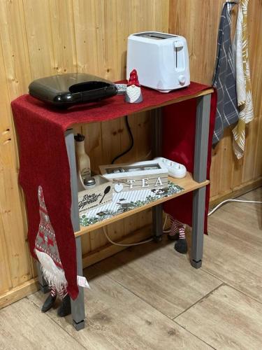 a red table with a toaster on top of it at Cabanutze Satic in Rucăr