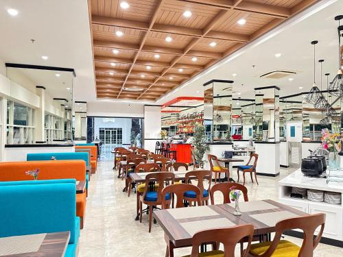a restaurant with tables and chairs and a cafeteria at d'primahotel Jemursari Surabaya in Surabaya