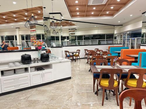 a dining room with tables and chairs in a restaurant at d'primahotel Jemursari Surabaya in Surabaya