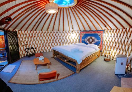 a bedroom in a yurt with a bed and a table at Nomad Yurts in Coron