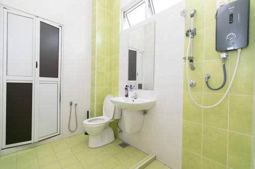 a bathroom with a toilet and a sink and a shower at BalikPulau Cozy Home 4BR w BBQ in Balik Pulau